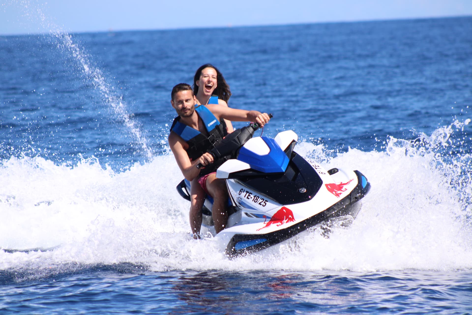 Pareja navegando en jet ski en aguas abiertas